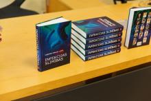 A stack of the new books on a table