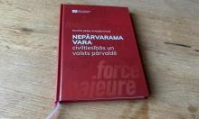 The book in question with a red cover, lying on a wood table