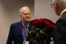 Professor Lācis receives bouquet of roses from the Rector