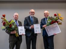 Prof. Gardovskis, Prof. Pētersons and Prof. Jumtiņš pose with flowers