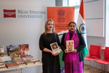 Representatives from RSU and the Embassy of India hold the donated book