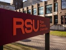 The university's new logo, orange text on burgundy background