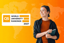 Woman against orange background holding books and looking at QS logo